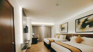 Una habitación de hotel con dos camas, un escritorio, una silla y un televisor.