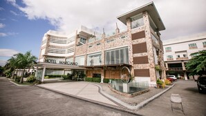 Un hotel moderno con fachada curva, amplias ventanas y una entrada destacada.