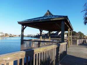 A wooden pier with a covered viewing area overlooking a body of water.