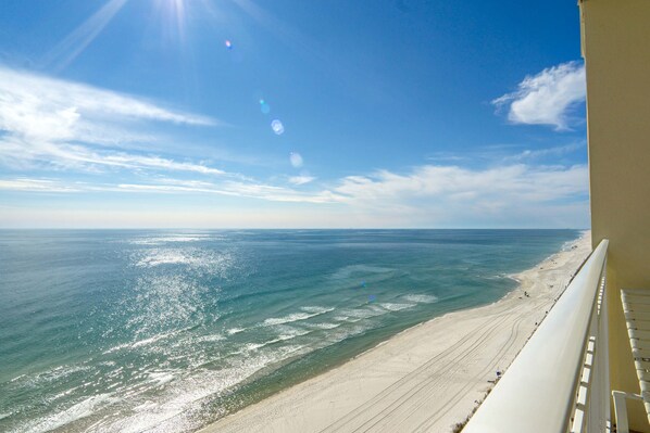 A beach view from a balcony with a clear sky and ocean. - Crystal Shores 1301 - Beautiful Beachfront Corner Condo with Gorgeous Views! (Gulf Shores)