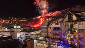 A hotel with multiple floors, a ski lift visible in the background, and a view of a snowy mountain.
