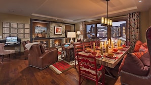 A dining area with a fireplace, a television, and a city view.