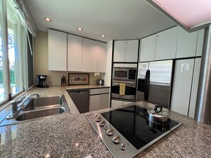 A modern kitchen with granite countertops, stainless steel appliances, and a built-in oven.