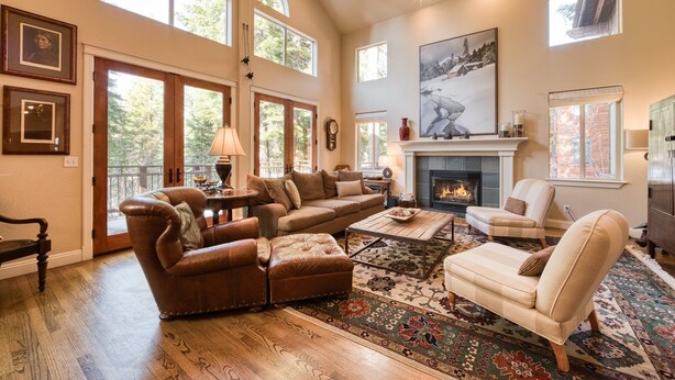 A spacious living room with a fireplace, leather sofas, a coffee table, and a large rug. - Big Springs by Tahoe Getaways - Luxury Northstar 6 BR - Free Ski Shuttle to Slopes (Truckee)