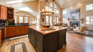 A spacious kitchen with wooden cabinets, a large island, and a chandelier. - Big Springs by Tahoe Getaways - Luxury Northstar 6 BR - Free Ski Shuttle to Slopes (Truckee)