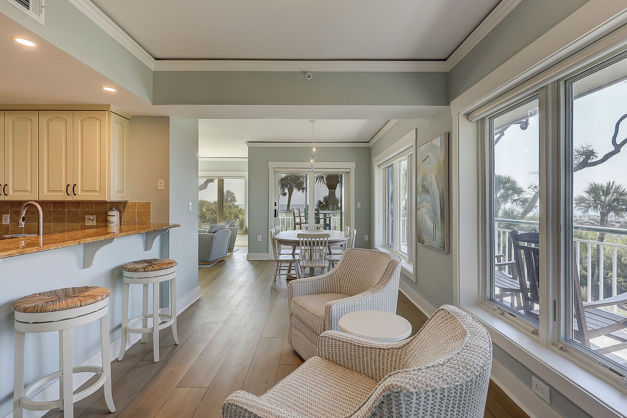A spacious interior with a kitchen, dining area, and seating by large windows.