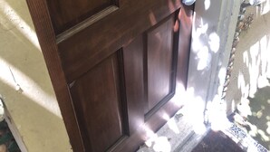A wooden door with a metal handle and a keyhole.
