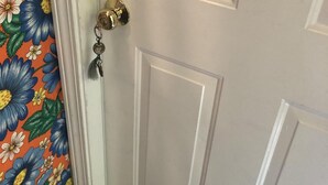 A white door with a brass doorknob and a keychain.
