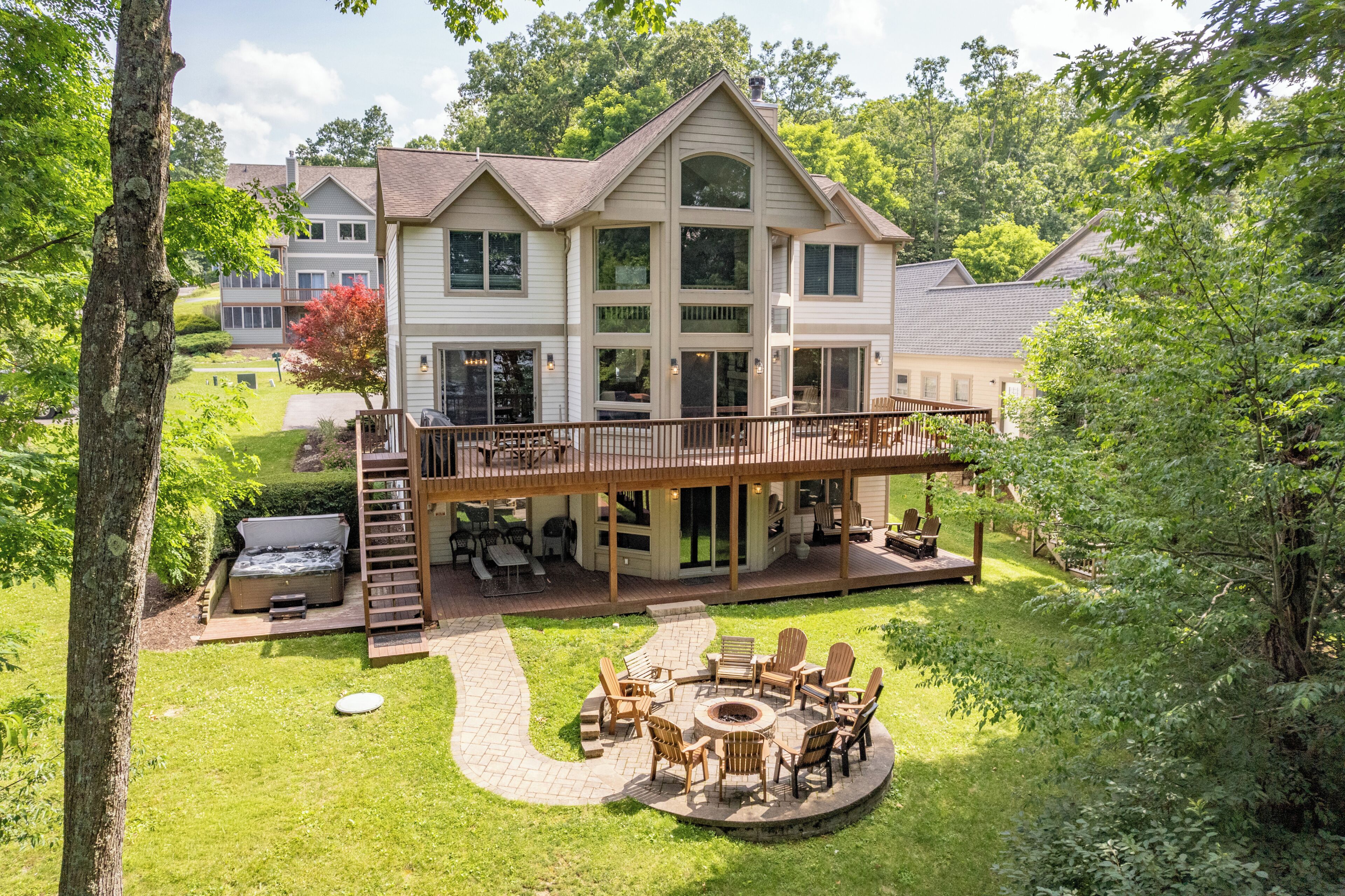 Een huis met twee verdiepingen, een terras, een buiten zitgedeelte en een jacuzzi.