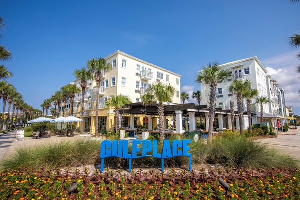 A hotel with a sign reading "Culebra Place" surrounded by palm trees and outdoor seating.