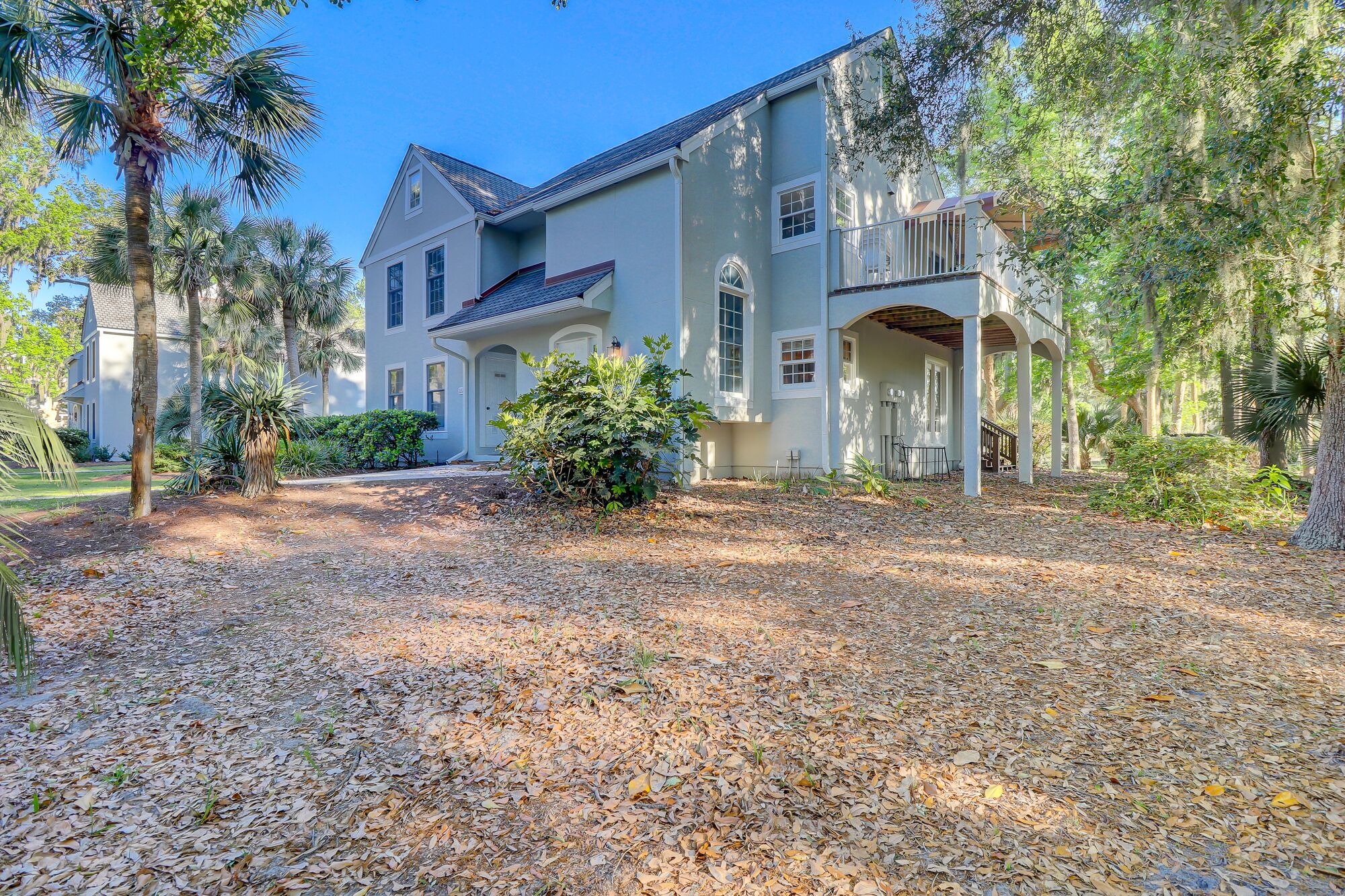 A two-story house with a covered porch and a landscaped driveway.