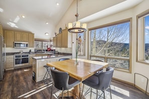 A modern kitchen with wooden cabinets, stainless steel appliances, and a large island with bar stools.