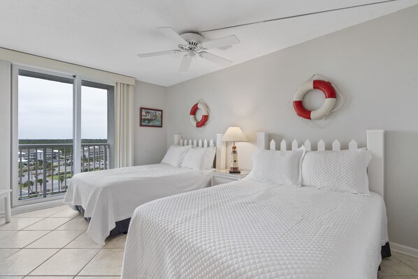 A hotel room with two beds, a balcony with a view, and life-saving rings on the wall. - Romar Tower 9A by Liquid Life (Orange Beach)