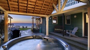 A hot tub under a wooden pergola with a view of the ocean. - Steps to the beach, hot tub, sand toys, families love this house. (Lincoln City)