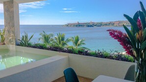 Ein Poolbereich mit Blick auf das Meer und eine entfernte Insel.