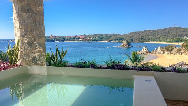 Ein Pool mit freiem Blick auf das Meer und einen Sandstrand.