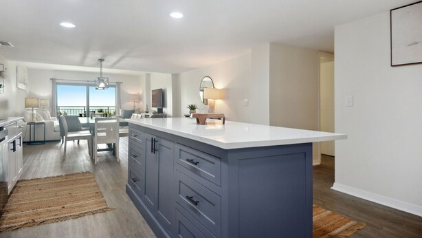Een moderne keuken met een centraal eiland, inbouwkeuken en een eetgedeelte met uitzicht.