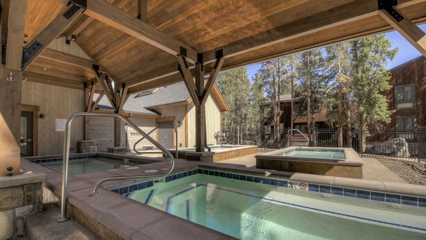 A pool area with a wooden deck and a hot tub. - Motherlode Condo: Walk to Downtown, Slopes (Breckenridge)