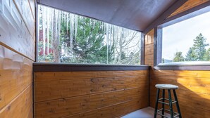 A wooden cabin interior with a window overlooking a forest. - Motherlode Condo: Walk to Downtown, Slopes (Breckenridge)