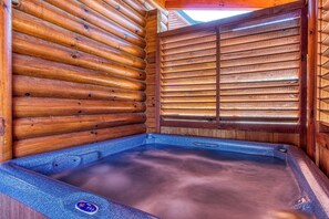 A wooden cabin interior with a hot tub.