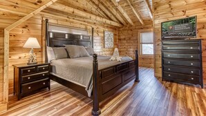 A wooden cabin bedroom with a bed, nightstands, dresser, and a ceiling fan. - Cabin w/Great Mountain Views-Theater-Arcade-Hot Tub (PIGEON FORGE)