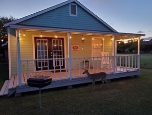 Ein kleines Haus mit Veranda, Tür und Fenster.