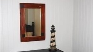 A dark wooden dresser with four drawers and a mirror with a wooden frame. - Laguna Flats Lodge. 3 Bedroom, 2 Bath. Close to Public Pier or Boat Launch. (Port Mansfield)
