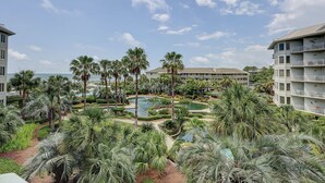 A resort with multiple buildings, a central pool, and palm trees.
