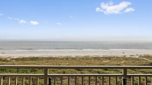 A beach view from a balcony with a railing, sandy beach, and ocean. - Ocean One 413 - Oceanfront 4th Floor Condo (Hilton Head Island)
