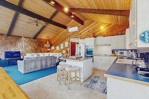 Una cocina moderna con armarios blancos, una isla central y un microondas.