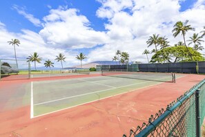 A tennis court with a net, surrounded by palm trees and a clear sky. - Maui Sunset Vacation Rentals B304 (Kihei)