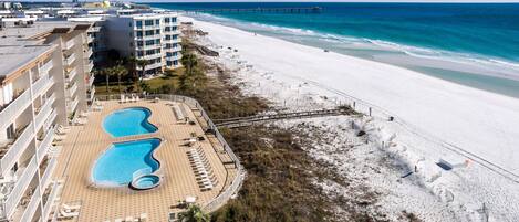 A resort with a beach, a pier, and a pool area.