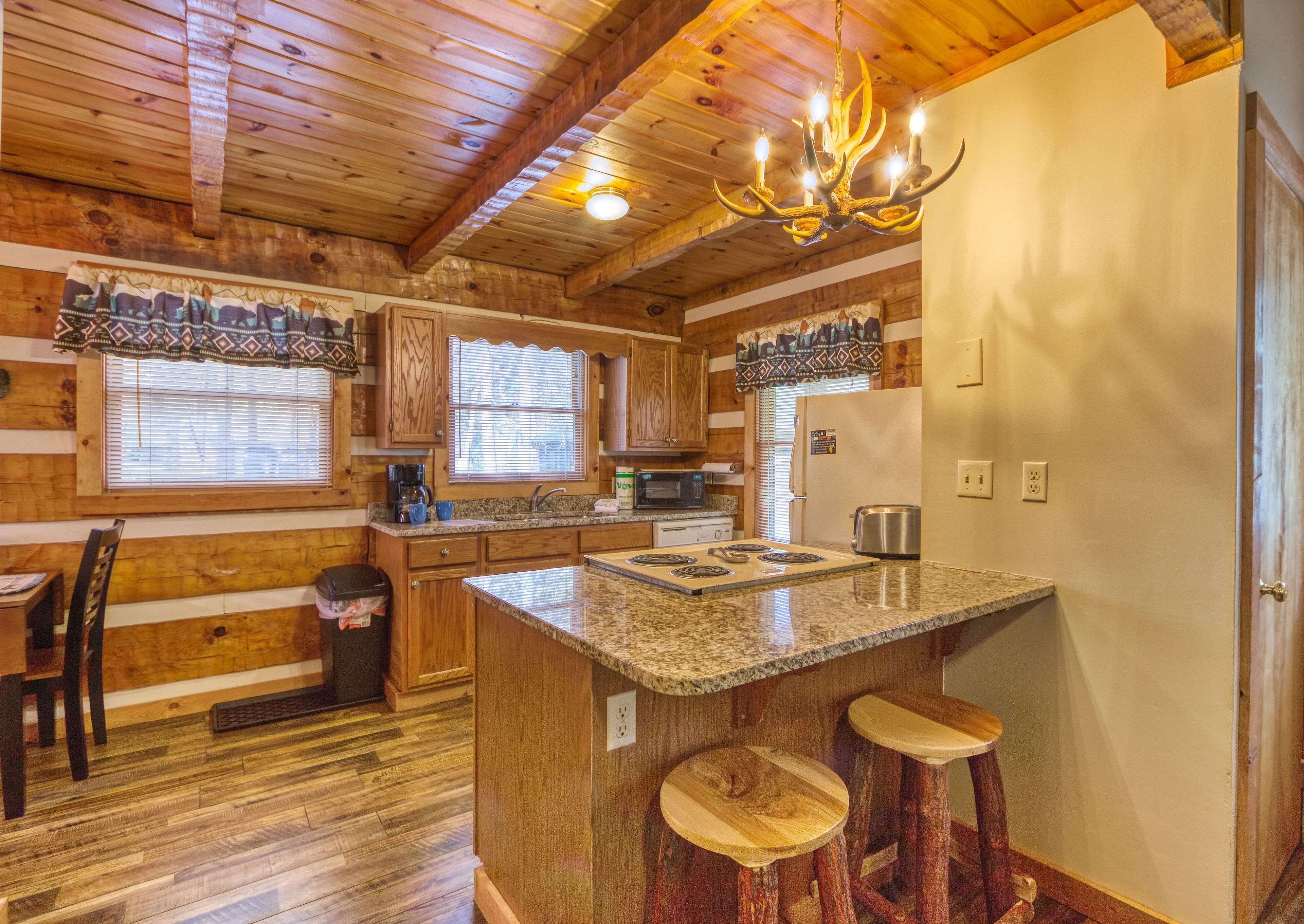 A kitchen with wooden cabinets, a granite countertop, a built-in stove, and a chandelier.