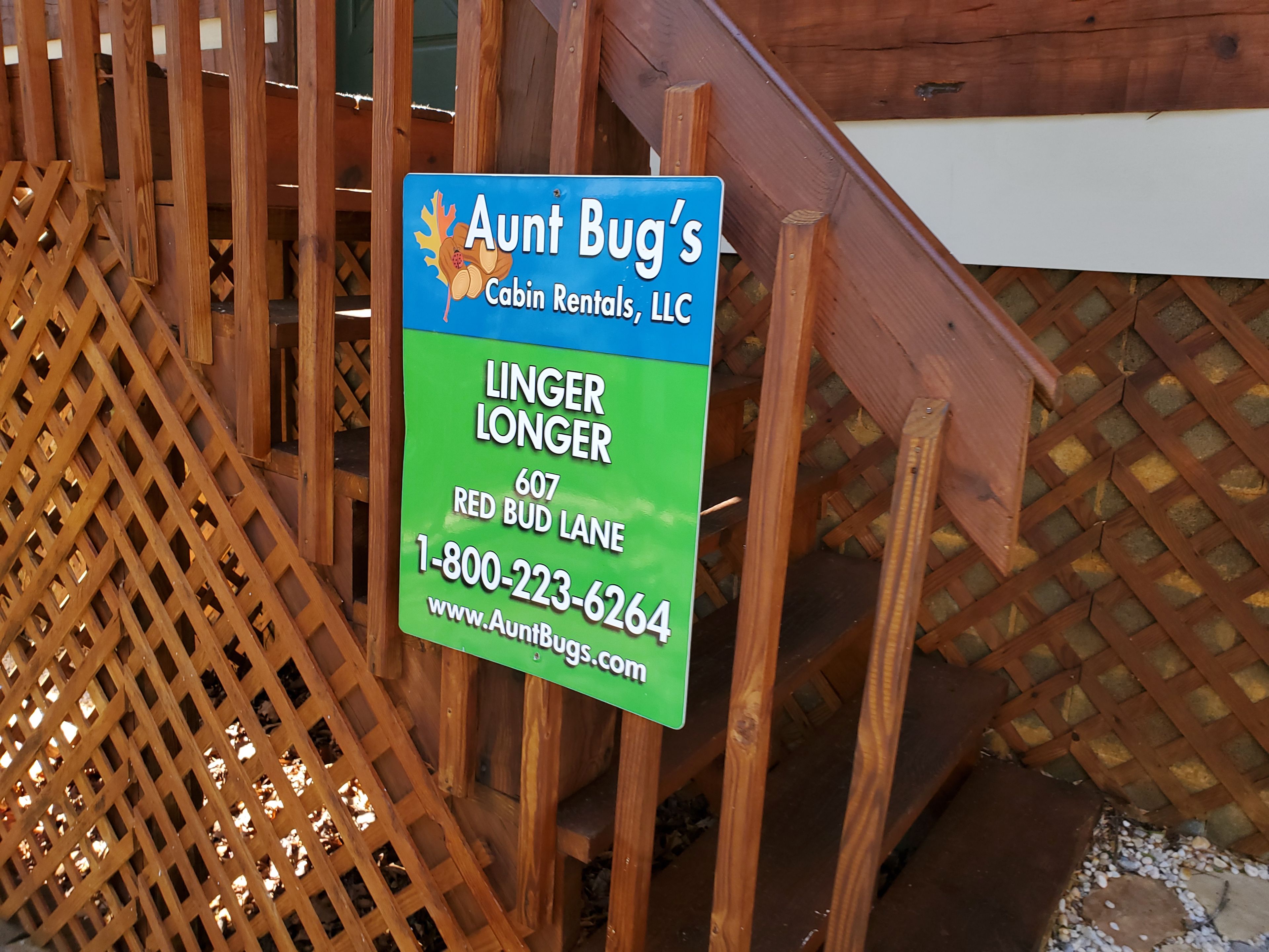 A sign for 'Aunt Bug's Cabin Rentals, LLC' with contact information and a website URL.