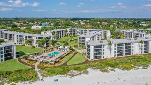 A resort with multiple buildings, a swimming pool, and a beach area.
