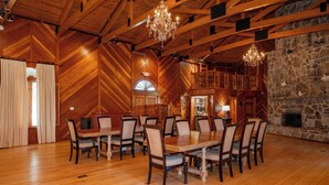 A large wooden dining room with a stone fireplace and a balcony. - 20-Acre Estate w/ Pool, Games & Meeting Space (Oakland)