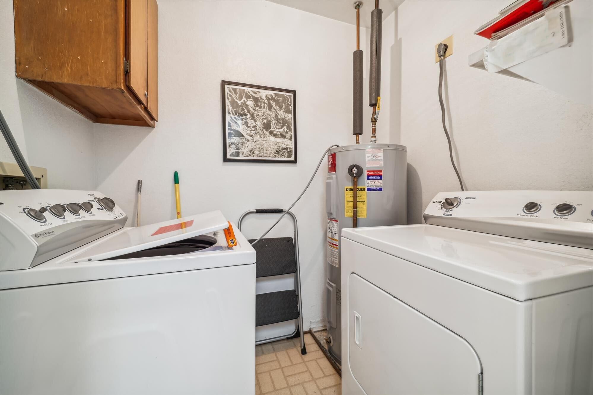 A laundry room with a washing machine, dryer, and a water heater.