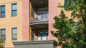 Un immeuble à plusieurs étages, doté d’une façade en briques, d’une entrée abritée et d’un parcmètre.