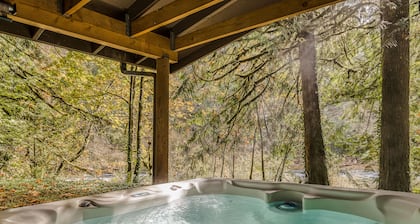 Spacious riverfront lodge with beach access, private hot tub & forest views