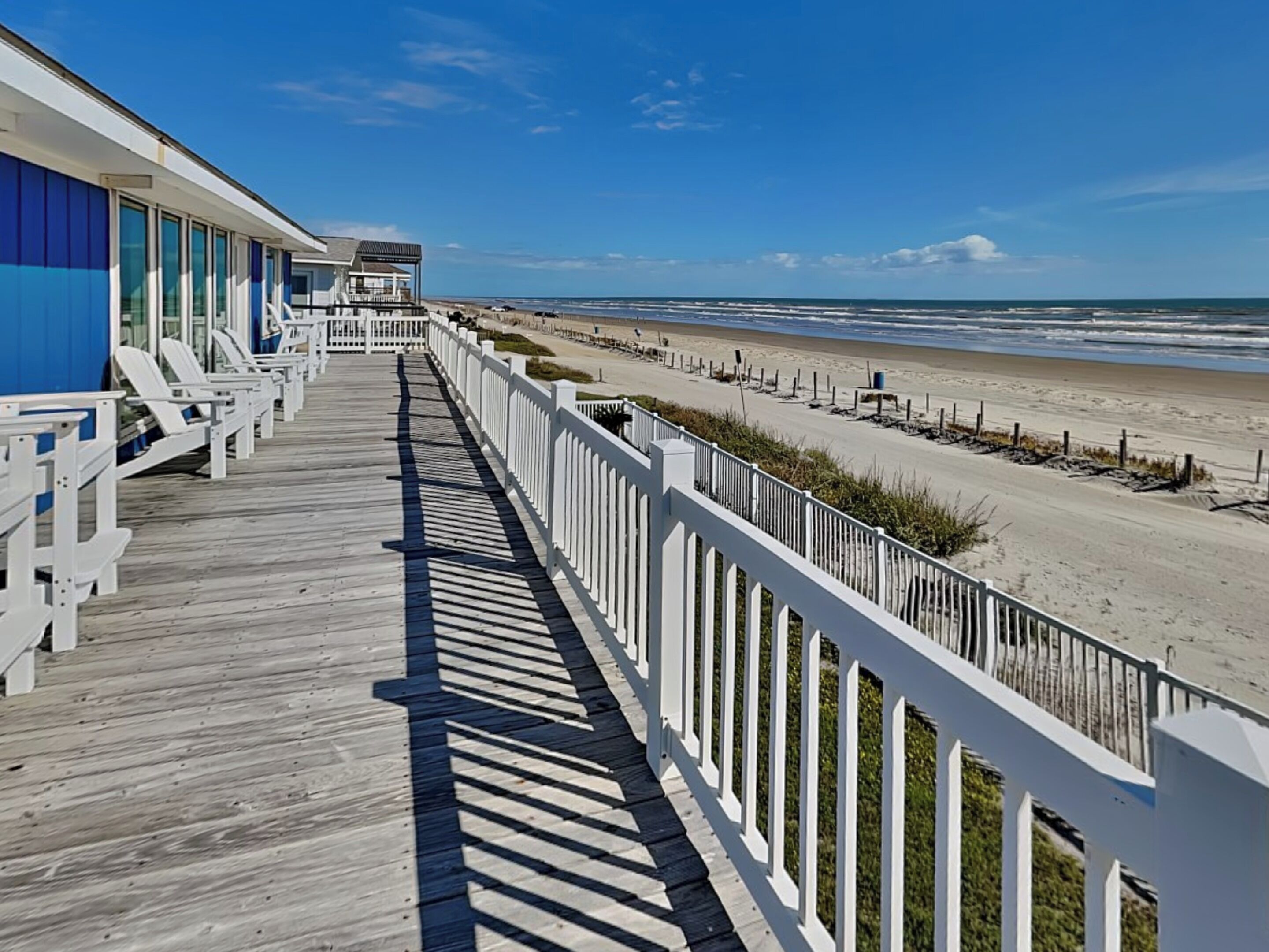 Une promenade en bois qui mène à une plage offrant une vue sur l’océan.