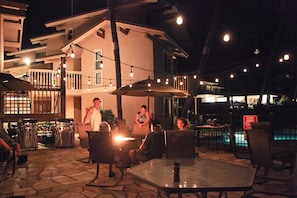 Relax by the poolside patio, where tables and chairs under umbrellas invite you to unwind.