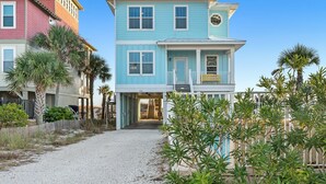 Una casa sulla spiaggia a due piani con un portico coperto e il numero '3093' ben visibile.
