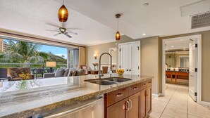 A modern kitchen with a large island, stainless steel appliances, and pendant lighting.