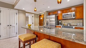 A modern kitchen with granite countertops, stainless steel appliances, and wooden cabinets.