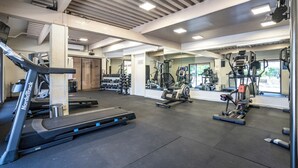 Una palestra con tapis roulant, macchinari per pesi e pesi liberi.