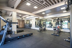 Een sportschool met loopbanden, krachtapparaten en losse gewichten.
