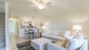 A spacious living room with a sofa, ottoman, and a dining area with chairs. - LAKE PALMS 1 - Sanibel Condo Overlooking Lagoon (Sanibel)
