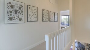 A staircase with a white railing leading to a room with a large window. - LAKE PALMS 1 - Sanibel Condo Overlooking Lagoon (Sanibel)