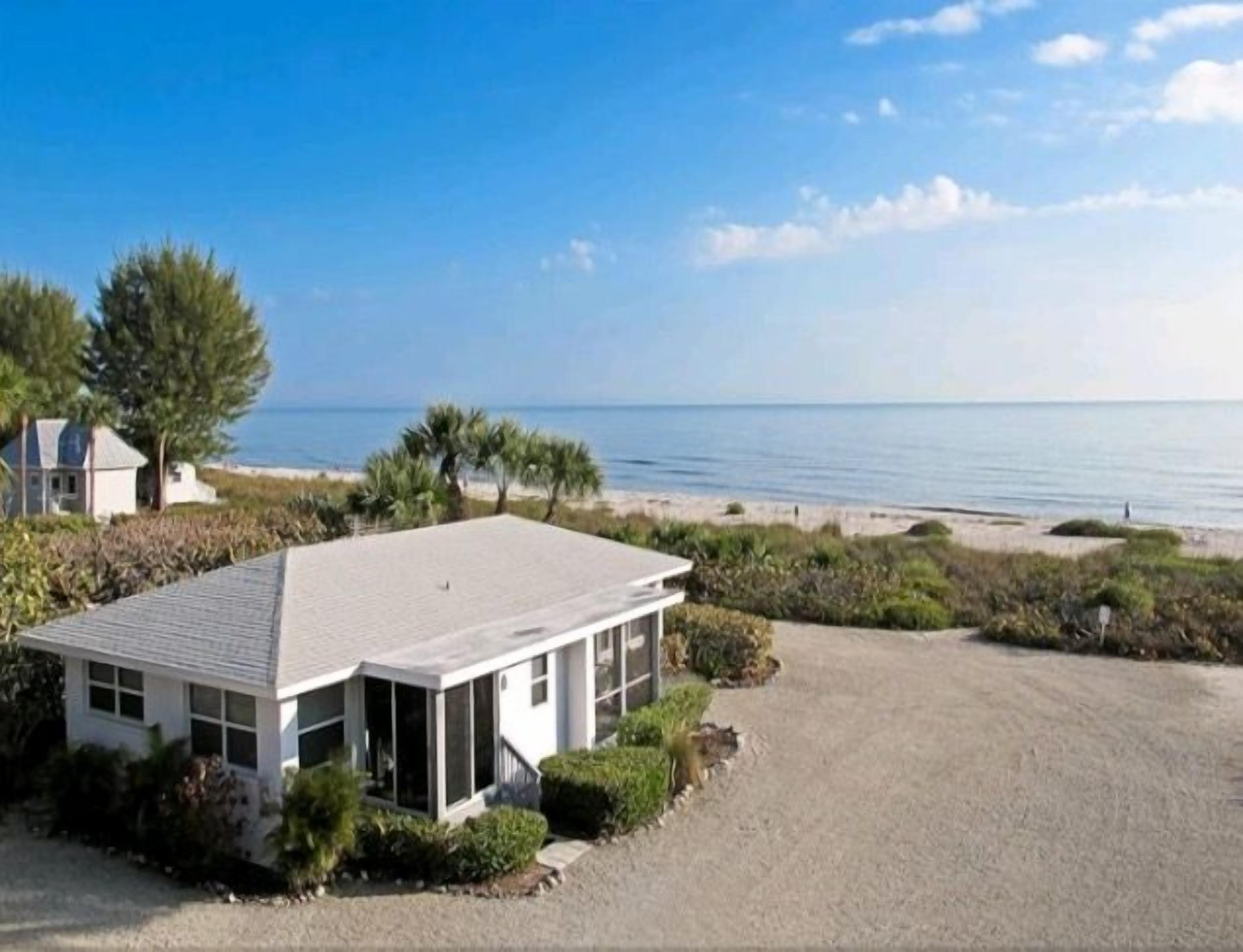 A modern house with a large garage and a view of the beach.