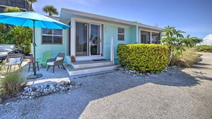 A modern house with a covered patio, outdoor seating, and a well-maintained garden.